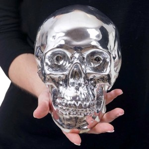 MCW Deko Totenkopf T921, silberne Totenkopf Figur aus Polyresin, gehalten in Händen.