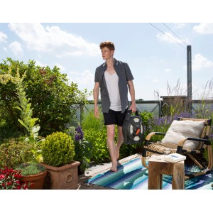 Mann trägt Gardena city Gardening Terrassen Schlauchbox 10m durch Garten.