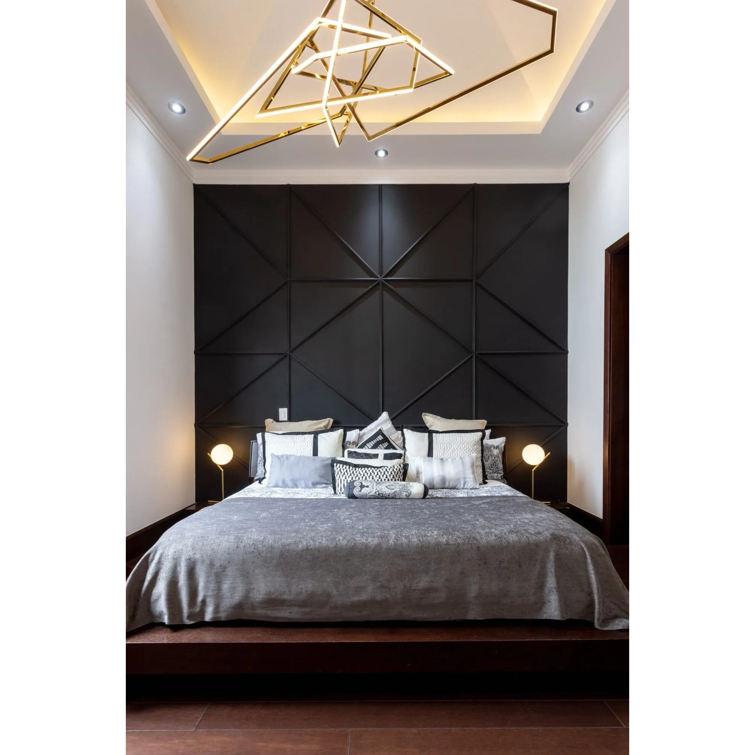Schlafzimmer mit schwarzer Wandverkleidung aus Paneelen und indirekter Beleuchtung.