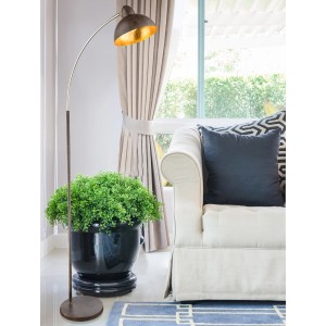 Globo Stehleuchte Anita, rostfarbig, im Wohnzimmer neben Sofa und Pflanze.