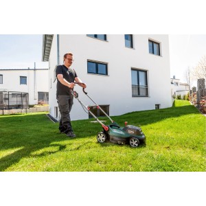 Mann mäht Rasen mit Metabo Akku-Rasenmäher RM 36-18 LTX BL 36 im Garten.