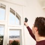 Mann misst mit Bosch UniversalTemp Infrarot-Thermometer Temperatur eines Fensters.