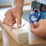 LUX Mini-Maßband 2 m im Einsatz: Hand misst Holz mit blauem Rollbandmaß.