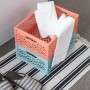 Zwei gestapelte Klappboxen Midi (türkis, orange) mit Handtüchern auf einem gestreiften Teppich.
