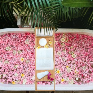 Badewanne mit Blüten und Zitrone, darauf eine HOMCOM Badewannenablage aus Bambus mit Buch, Kerze und Handtuch.