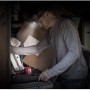 Mann mit Energizer Kopflampe Universal + Headlamp beim Werkeln im dunklen Raum.