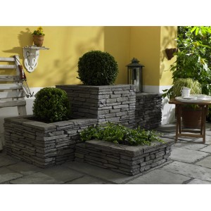 Ziermauer Madoc Füllsteine in Schiefergrau als dekorative Pflanzkästen im Garten.