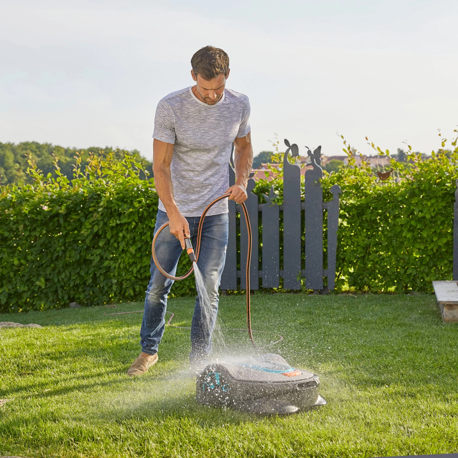 Gardena Mähroboter Sileno life 750 wird mit Wasserschlauch gereinigt.