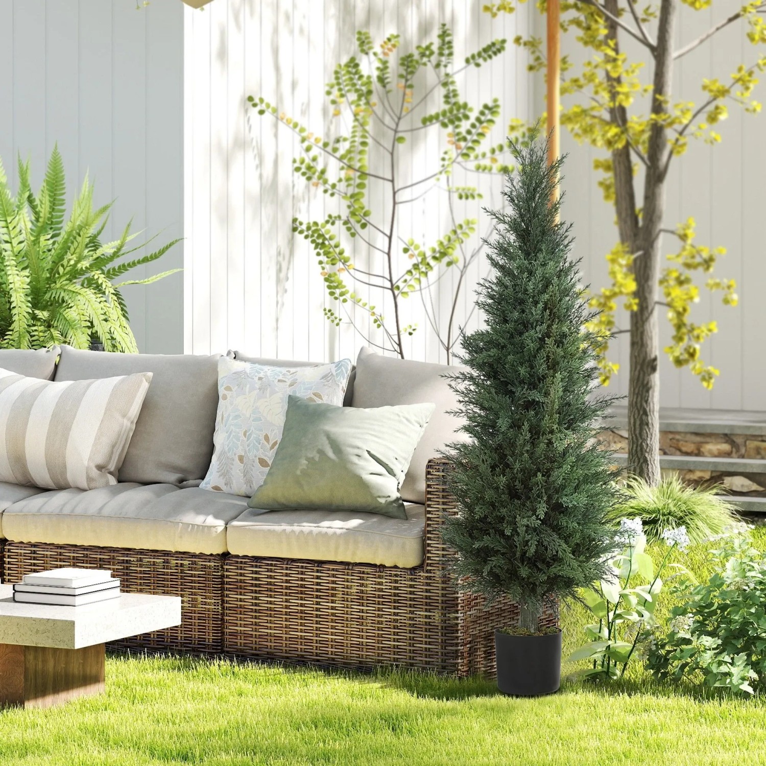 Große künstliche Zypresse 120 cm im Topf, grün, UV-beständig, als Gartendekoration neben Outdoor-Sofa.