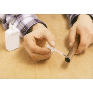 Anwendung von LUX Fittingslötpaste auf ein Kupferrohr. Lötmittel für dauerhafte Verbindungen.