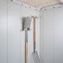 Innenansicht Biohort Gerätehaus Neo 2B. Helle Metallwände, Holzdecke, Spaten und Heugabel an Haken zur Aufbewahrung.
