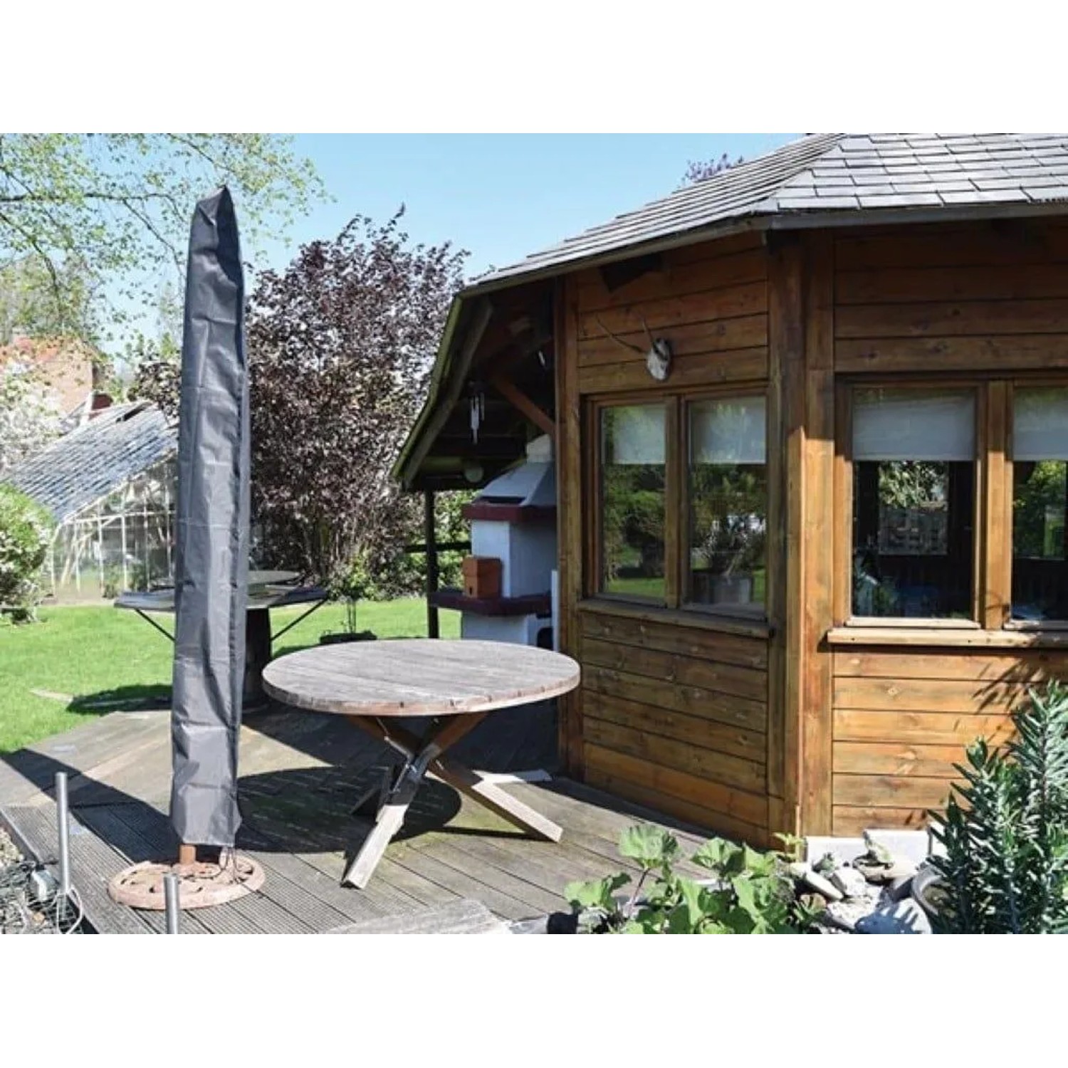 Schwarze Perel Schutzhülle für Sonnenschirm auf Holzterrasse neben Gartenhaus. Optimaler Schutz.