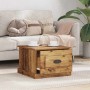 Quadratischer Couchtisch in Altholz-Optik mit offener Schublade vor hellem Sofa im Wohnzimmer.