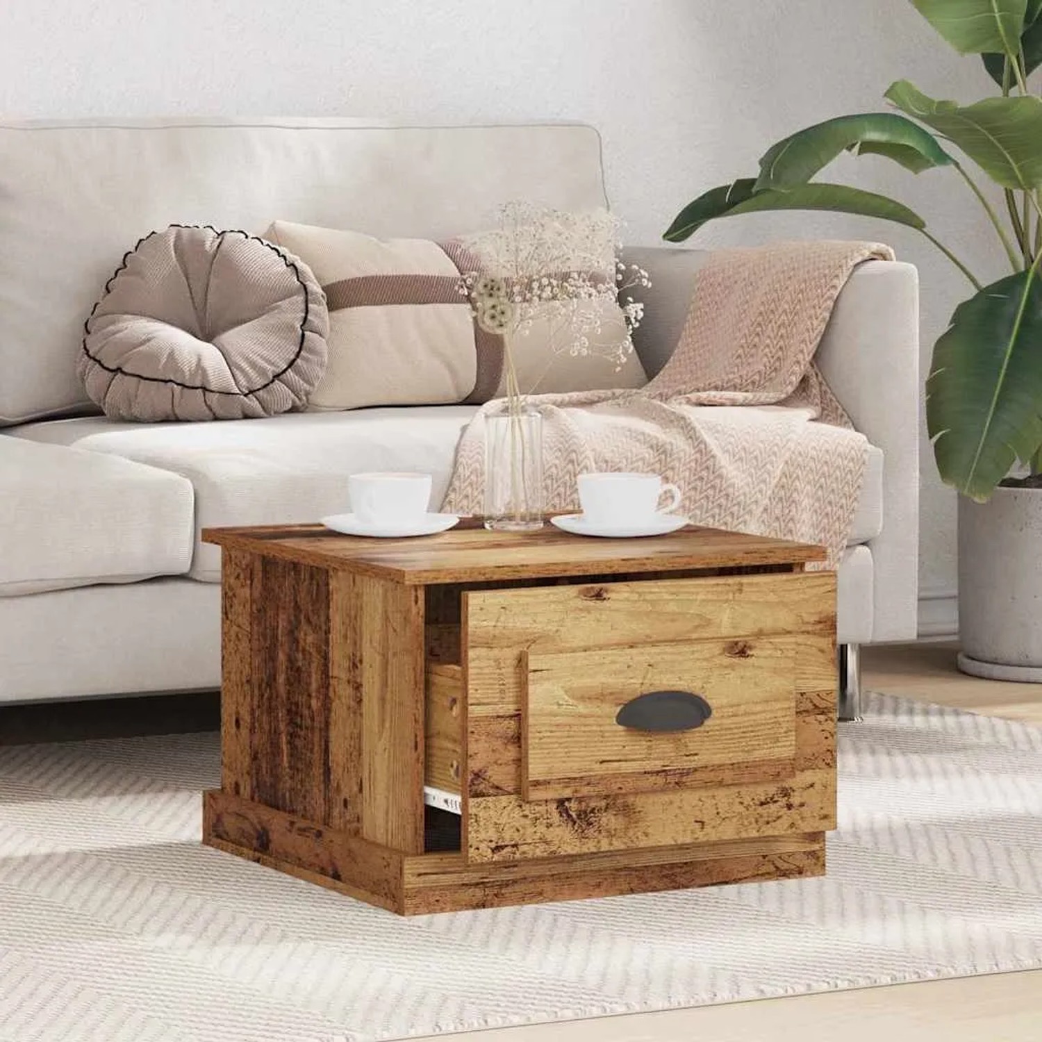 Quadratischer Couchtisch in Altholz-Optik mit offener Schublade vor hellem Sofa im Wohnzimmer.