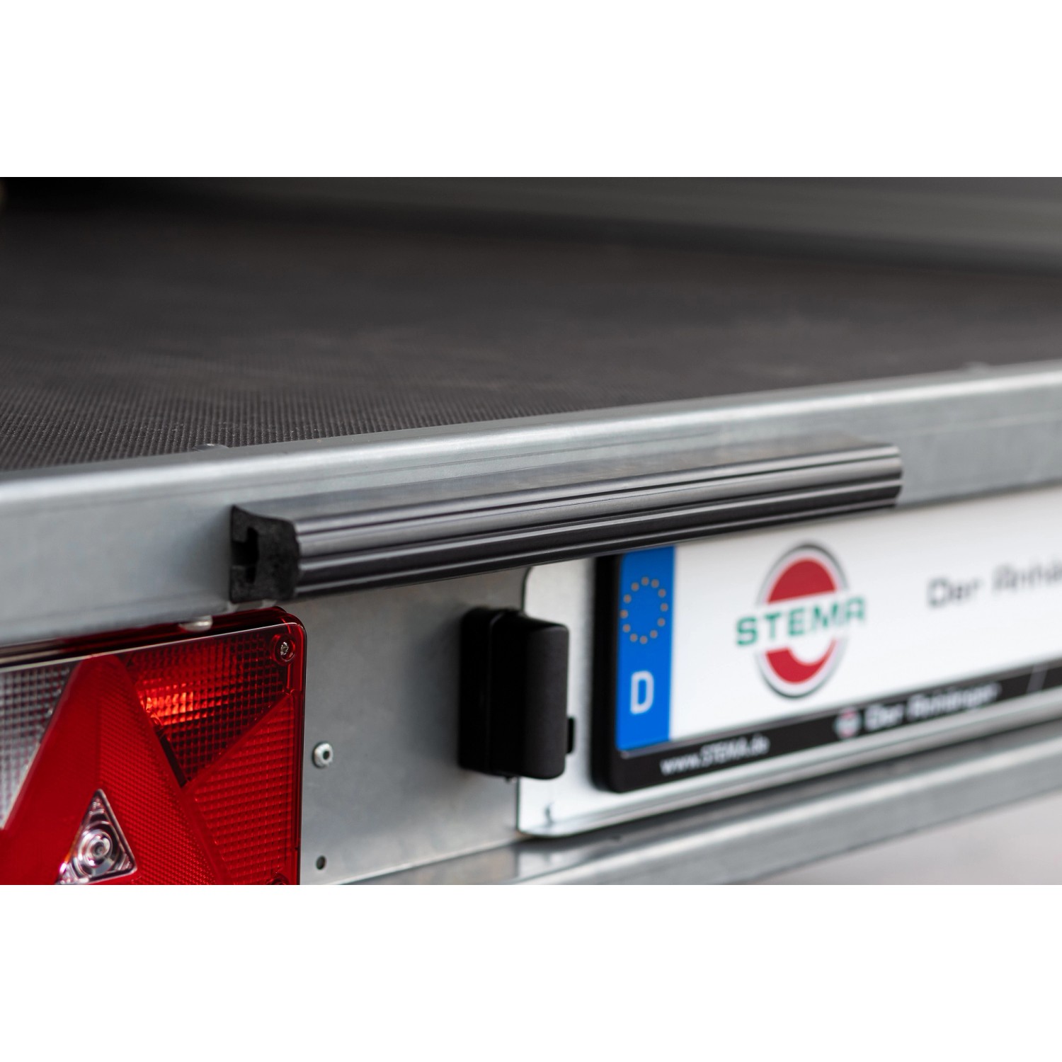 Detailansicht Stema Kofferanhänger 1300 Sandwich: Kennzeichen, Rücklicht und Rammschutz.
