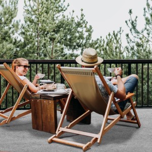 Grauer Primaflor Rasenteppich auf Terrasse mit entspannten Personen in Liegestühlen.