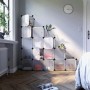 Weißes Songmics Regalsystem mit 16 Würfeln als Schuhkommode im Wohnraum.