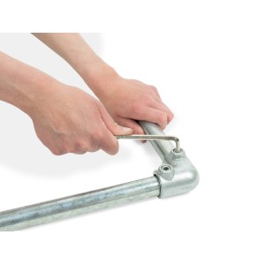 Montage des silbernen, verzinkten 90° Eckstücks für Stahlrohre (Ø 2,7 cm) mit Inbusschlüssel.