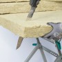 Wolfcraft Dämmstoffmesser schneidet Dämmmaterial auf einem Tisch. Profi-Werkzeug mit 305 mm Klinge.