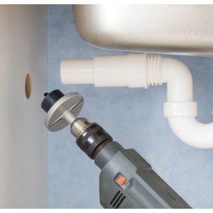 LUX Lochsäge-Set im Einsatz: Lochsäge bohrt Loch in Holzplatte unter Waschbecken.