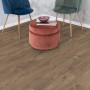 Egger NatureSense Aqua Laminat in Braun, verlegt in einem Raum mit Stühlen und Hocker.