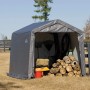 Graues Shelter Logic Metall-Gerätehaus 9 m² mit Gartengeräten und Holz im Inneren.