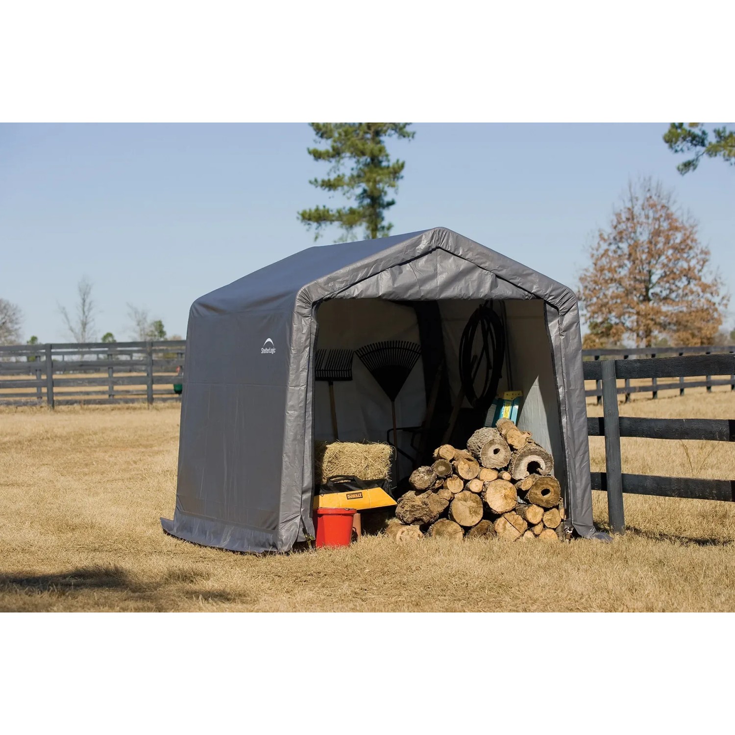 Graues Shelter Logic Metall-Gerätehaus 9 m² mit Gartengeräten und Holz im Inneren.