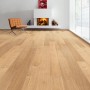 Helle Landhausdiele aus Eiche (Living by Haro Parkett) in Wohnraum mit Kamin und Sessel.