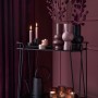 Dekorative schwarze Vase Midnight Mystery auf einem Servierwagen mit Kerzen und Teelichtern.
