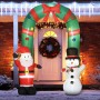 Aufblasbare Weihnachtsdeko mit Weihnachtsmann, Schneemann und beleuchtetem Torbogen vor Haustür im Schnee.
