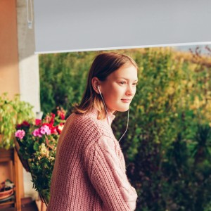 Graue Relaxdays Senkrechtmarkise am Balkon mit Mädchen. Sicht- und Sonnenschutz mit Seilzug.