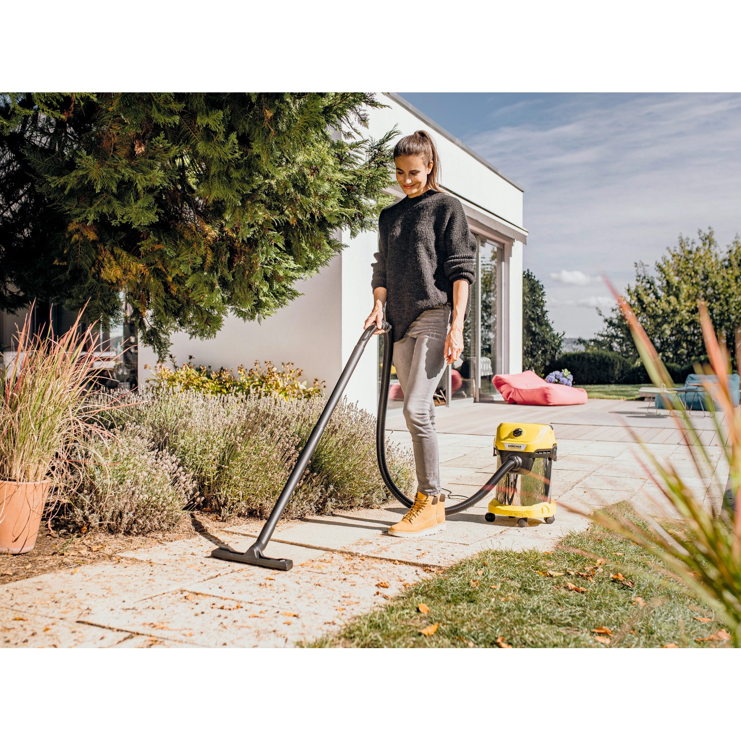 Frau nutzt Kärcher WD 3 S V-17/4/20 Nass-/Trockensauger im Außenbereich.
