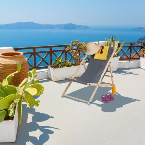 Anthrazitfarbener Relaxdays Klappliegestuhl aus Holz, 3-fach verstellbar, auf sonnigem Balkon mit Meerblick.
