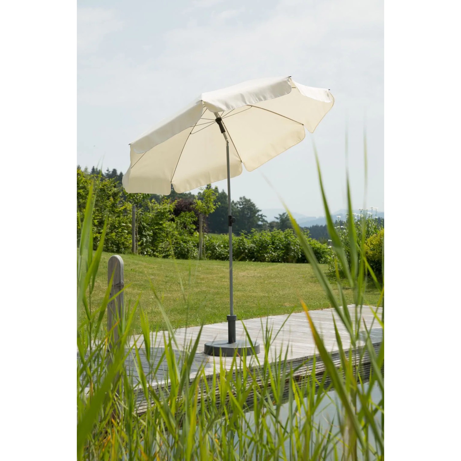 Naturfarbener Schneider Balkonschirm Locarno Ø 200 cm mit Knickfunktion auf Terrasse.