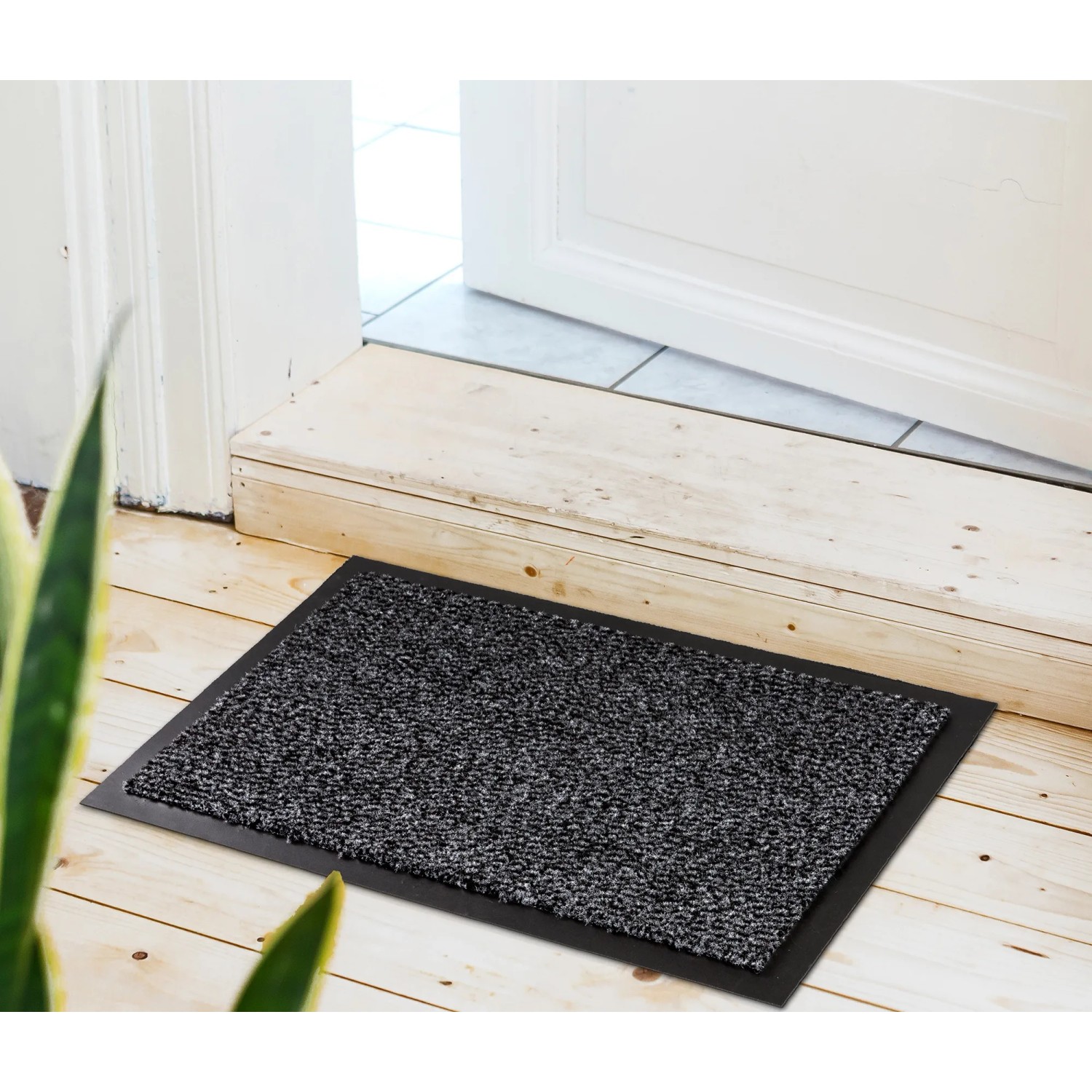 Graue Astra Türmatte Achat, 60x80 cm, vor einer Tür auf hellem Holzboden.