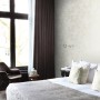 Beige Vliestapete mit Bambusblätter-Motiv von Origin Wallcoverings im Schlafzimmer.