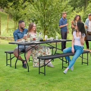 Schwarze Juskys Bierzeltgarnitur Amberg in Rattan Optik mit Tisch und Bänken im Garten.