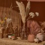 Dekorative braune Glasvase Desert Flower, 25 cm hoch, mit Rillenstruktur und verschiedenen Dekorationen.