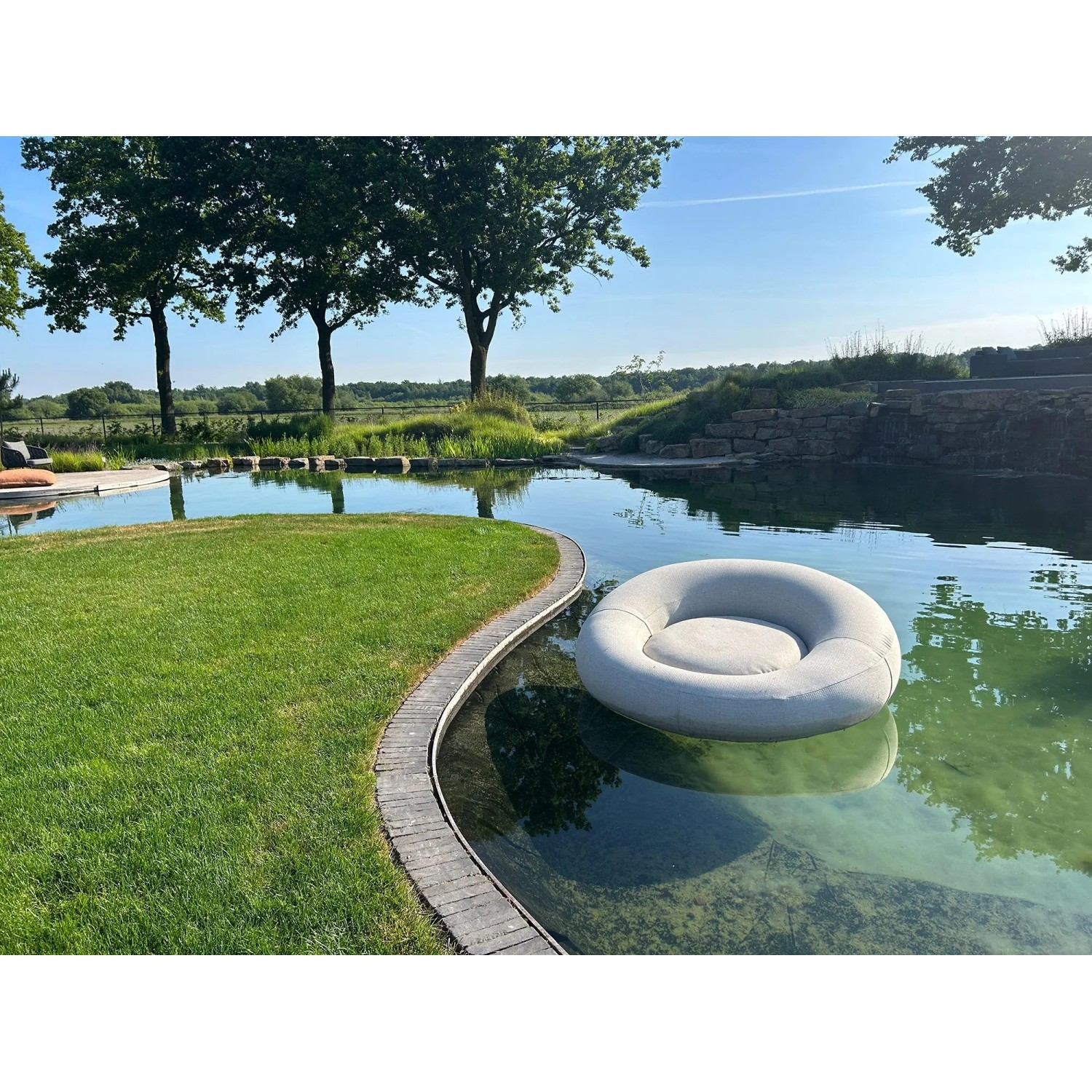 Anthrazitfarbenes Best Daybed Rondo, aufblasbare Luftmatratze im Gartenteich.