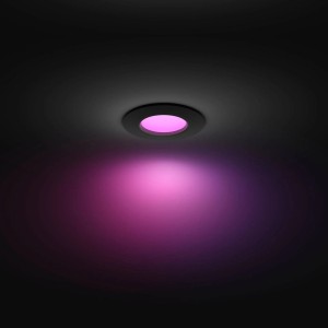 Schwarzer Philips Hue Einbauspot Slim mit farbigem Licht an der Decke.