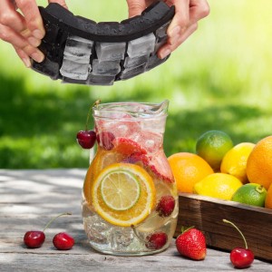 Hände lösen Eiswürfel aus flexibler Silikonform über Krug mit Fruchtgetränk. Ideal für Cocktails & Bar.