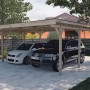 Weka Flachdach-Doppelcarport 616 aus Holz mit zwei parkenden Autos.