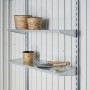 Regalsystem im Biohort Gerätehaus HighLine: Metallregale mit Pflanzgefäßen und Gartengeräten.