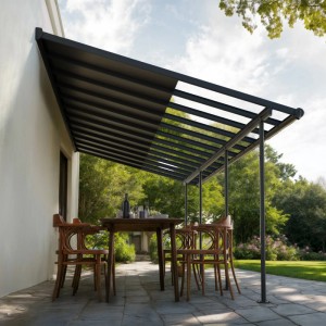 Graue Canopia Sierra Cabrio Terrassenüberdachung mit geöffnetem Schiebedach über Esstisch auf gepflasterter Terrasse.