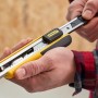 Stanley Cuttermesser FatMax™ 18 mm, schwarz-gelb, in Hand gehalten. Messer mit Klingenzufuhr.