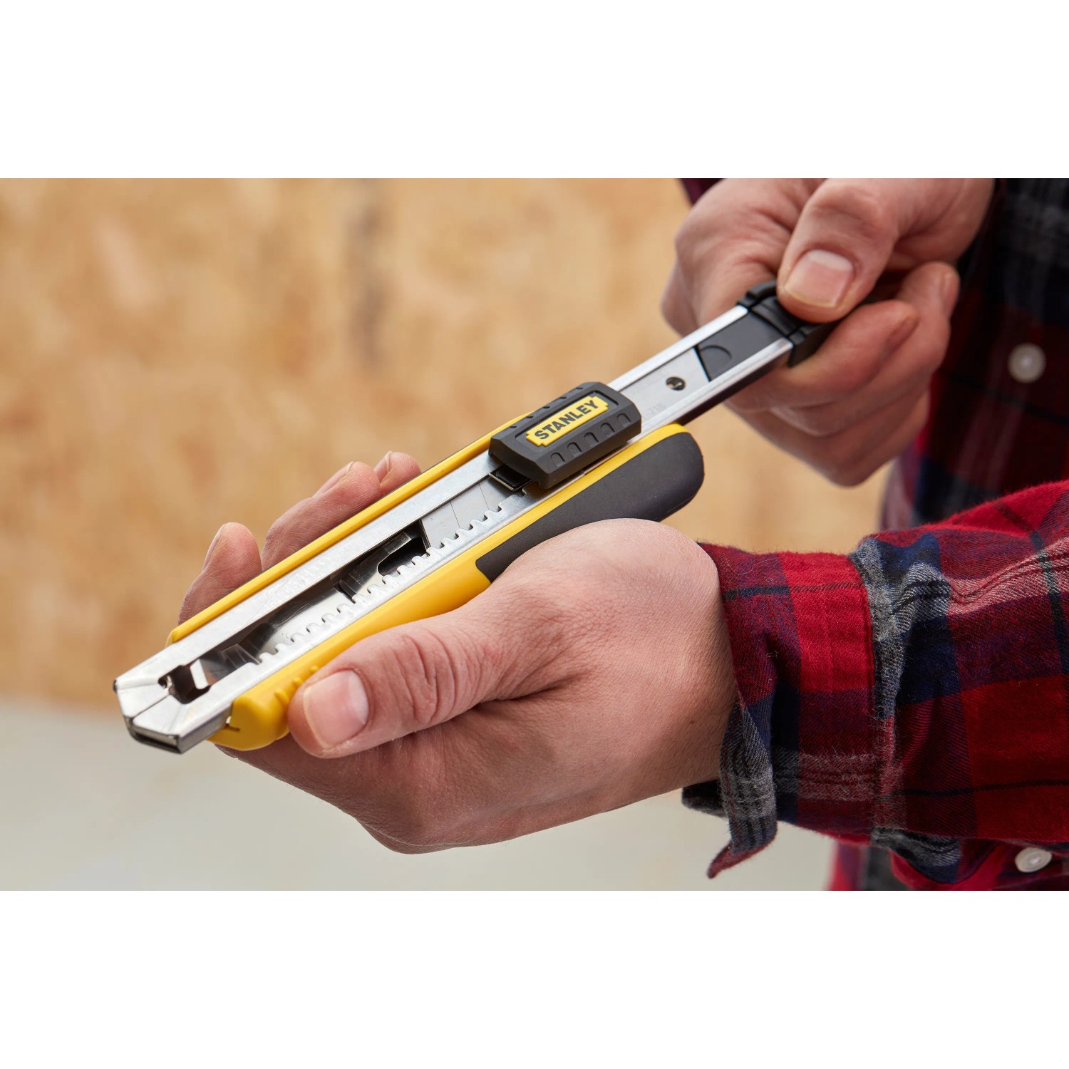Stanley Cuttermesser FatMax™ 18 mm, schwarz-gelb, in Hand gehalten. Messer mit Klingenzufuhr.