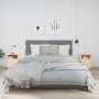 Zwei helle Nachttische aus massivem Kiefernholz mit offener Ablage und Tür, im Schlafzimmer neben einem Bett.