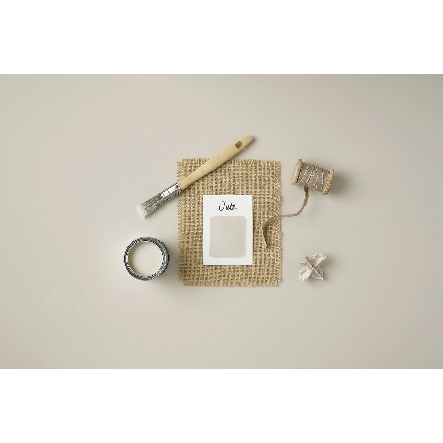 Rust-Oleum Küchenmöbellack Jute matt: Pinsel, Farbmuster, Stoff und Garn auf beigem Grund.