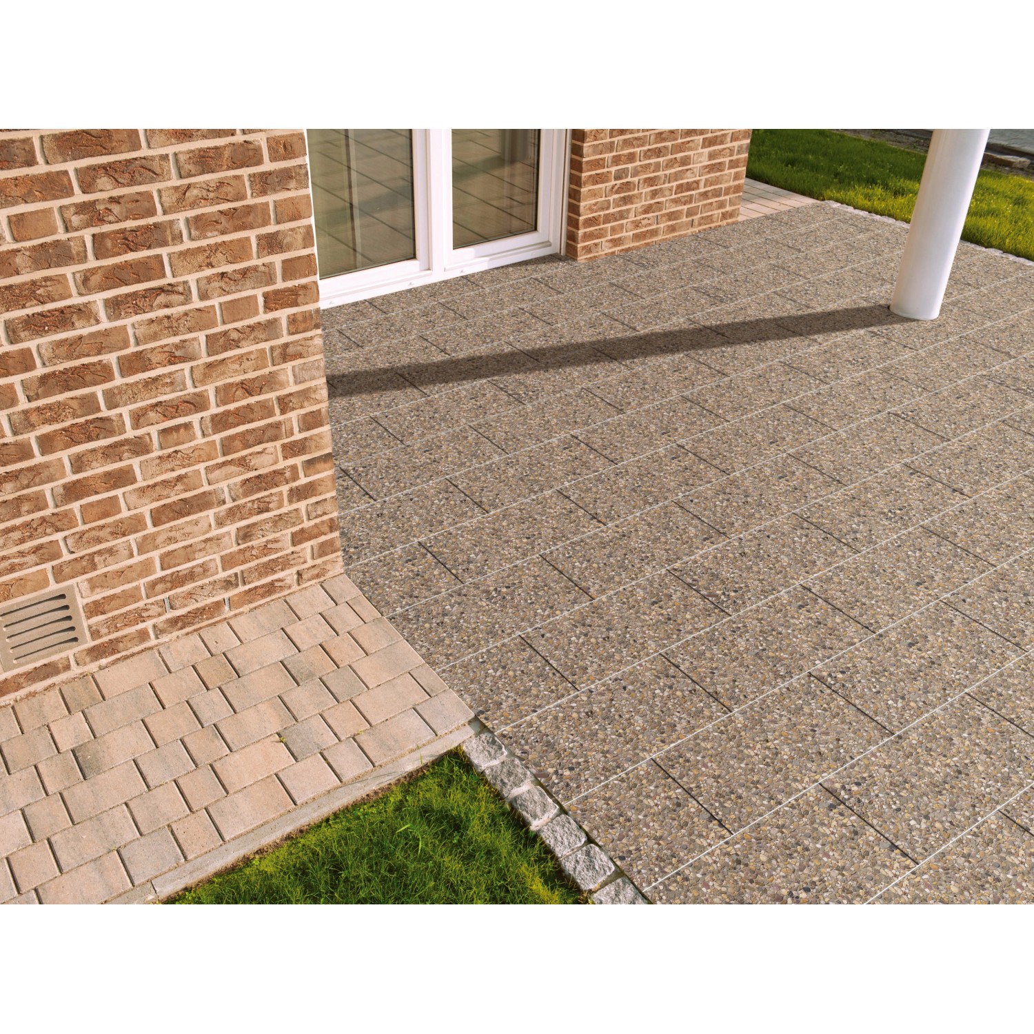 Verlegte Waschbetonplatten Buntkies 60x40 cm auf einer Terrasse. Gehwegplatten mit Kiesstruktur.