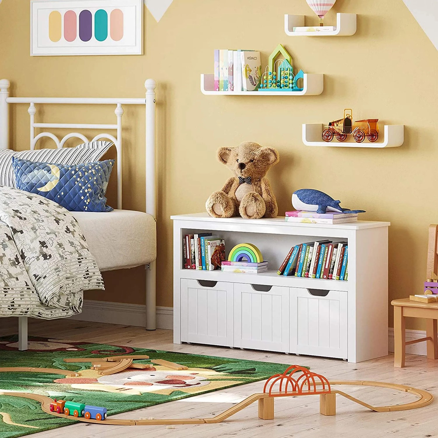 Weißer Vasagle Spielzeugschrank mit Rollen im Kinderzimmer mit Spielsachen und Deko.